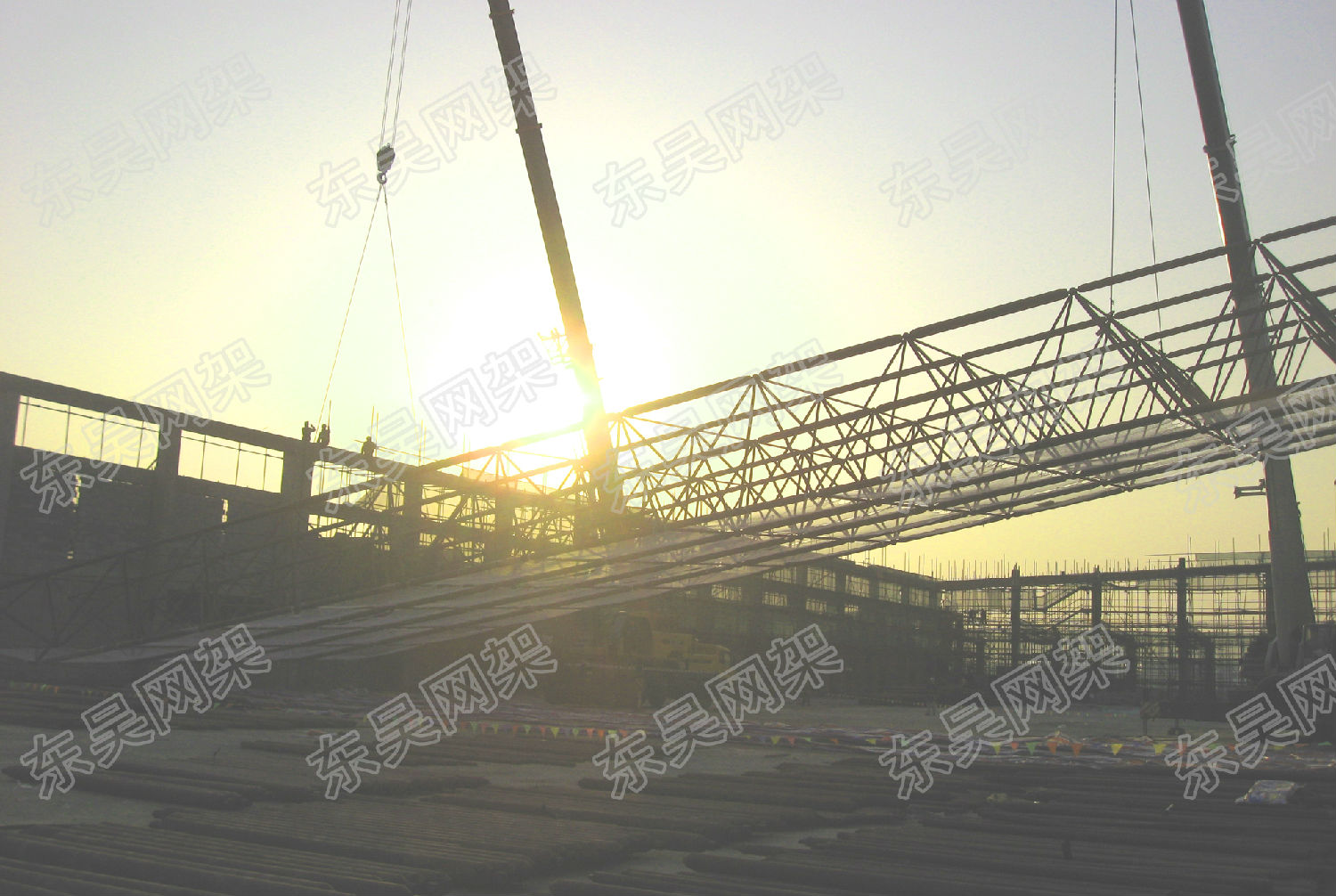 夕阳中的网架结构吊装